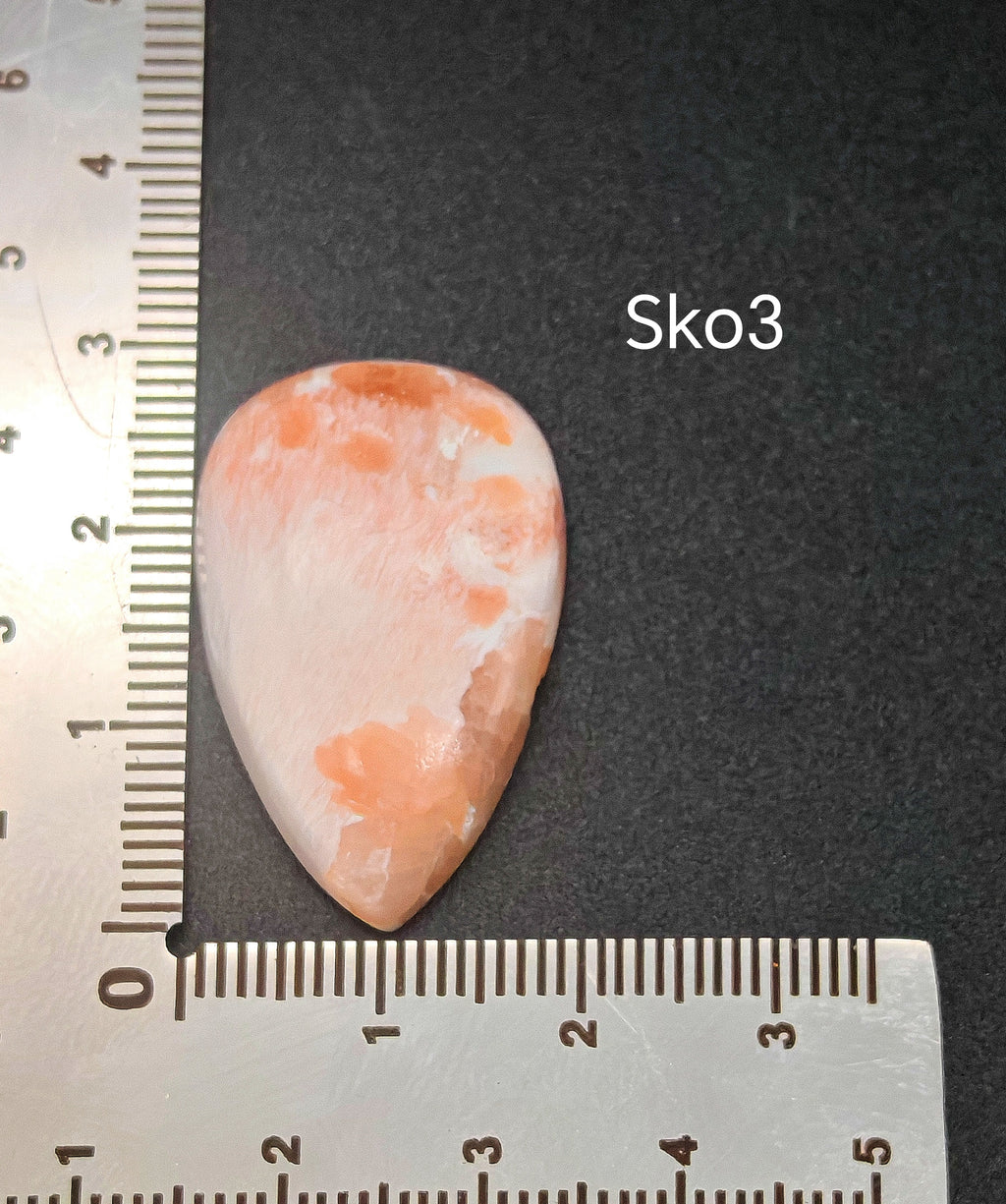  Rózsaszínes-fehér szkolecit kaboson vonalzón mérve, kb. 4,15 g súlyú természetes drágakő