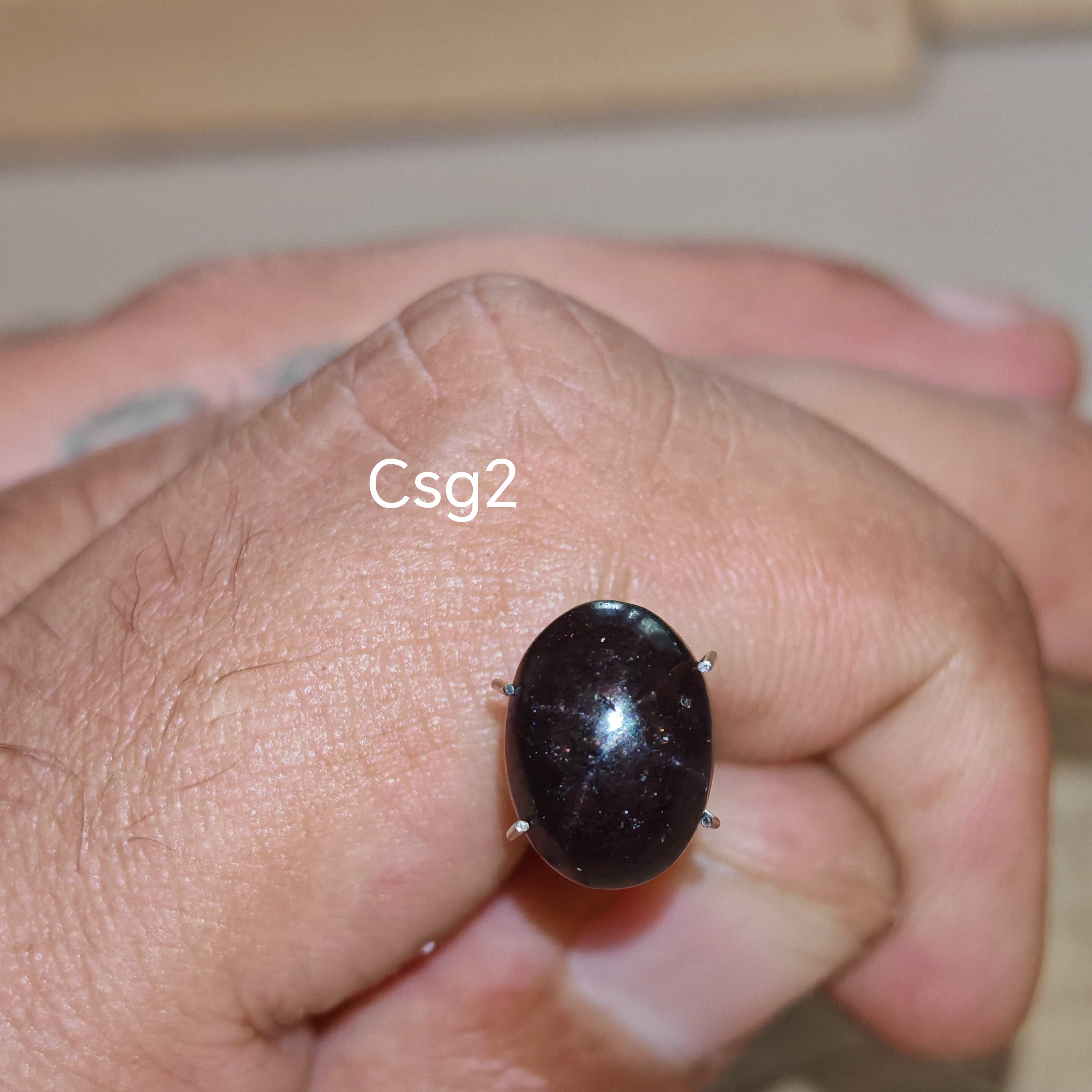 Star Garnet kabochon Csg2 – természetes csillag gránát kő kézben tartva, sötét bordó szín
