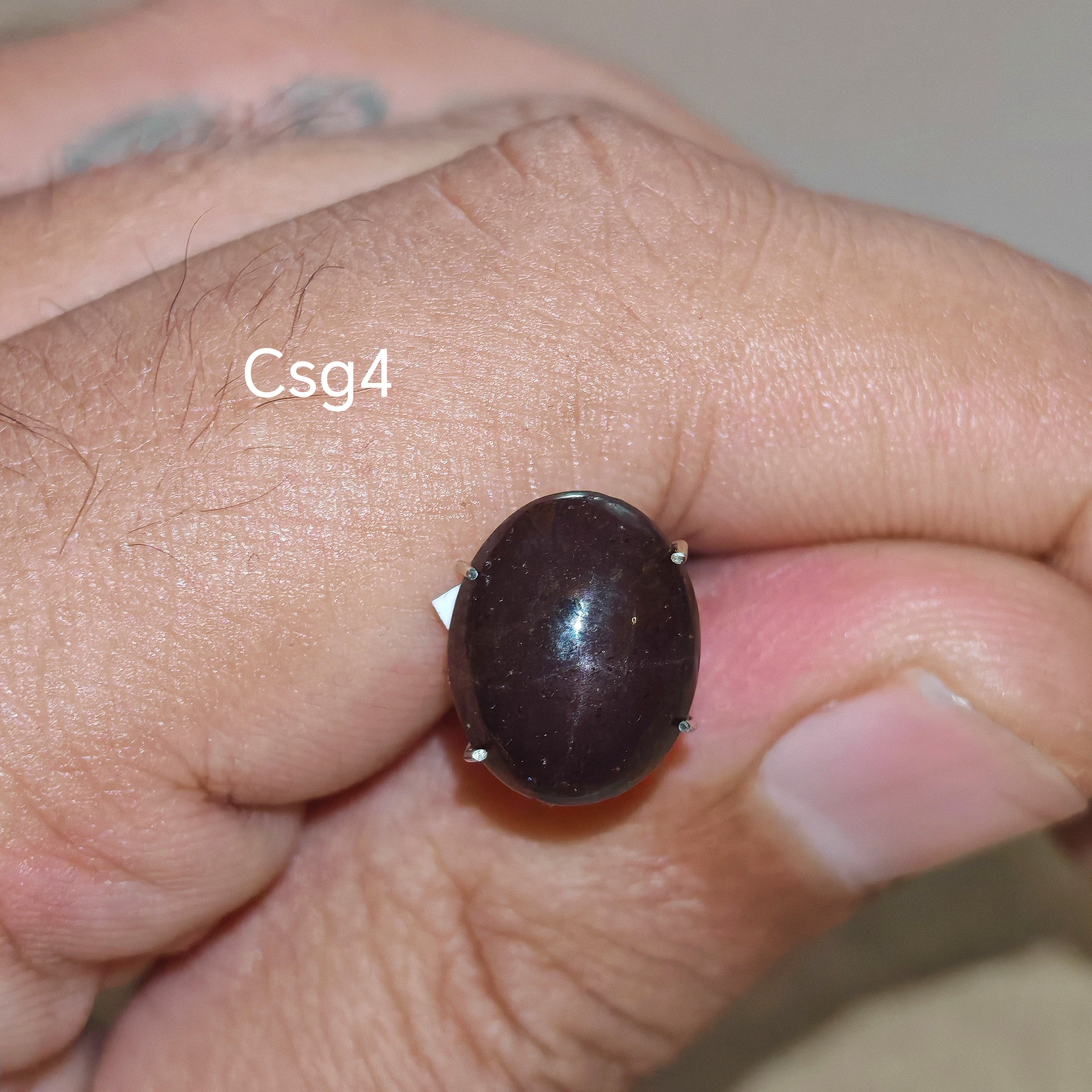 Star Garnet kabochon Csg4 – természetes csillag gránát kő kézben tartva, sötét bordó szín
