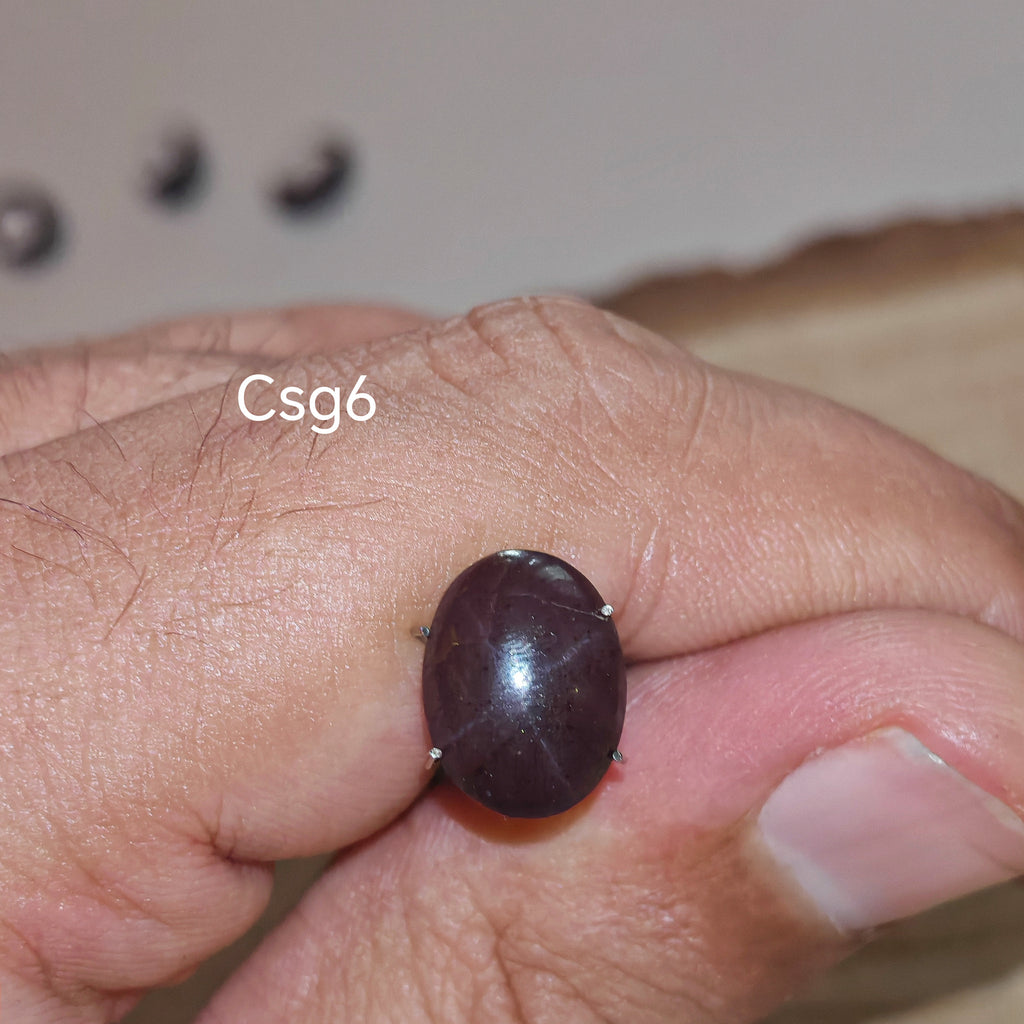 Star Garnet kabochon Csg6 – természetes csillag gránát kő kézben tartva, sötét bordó szín
