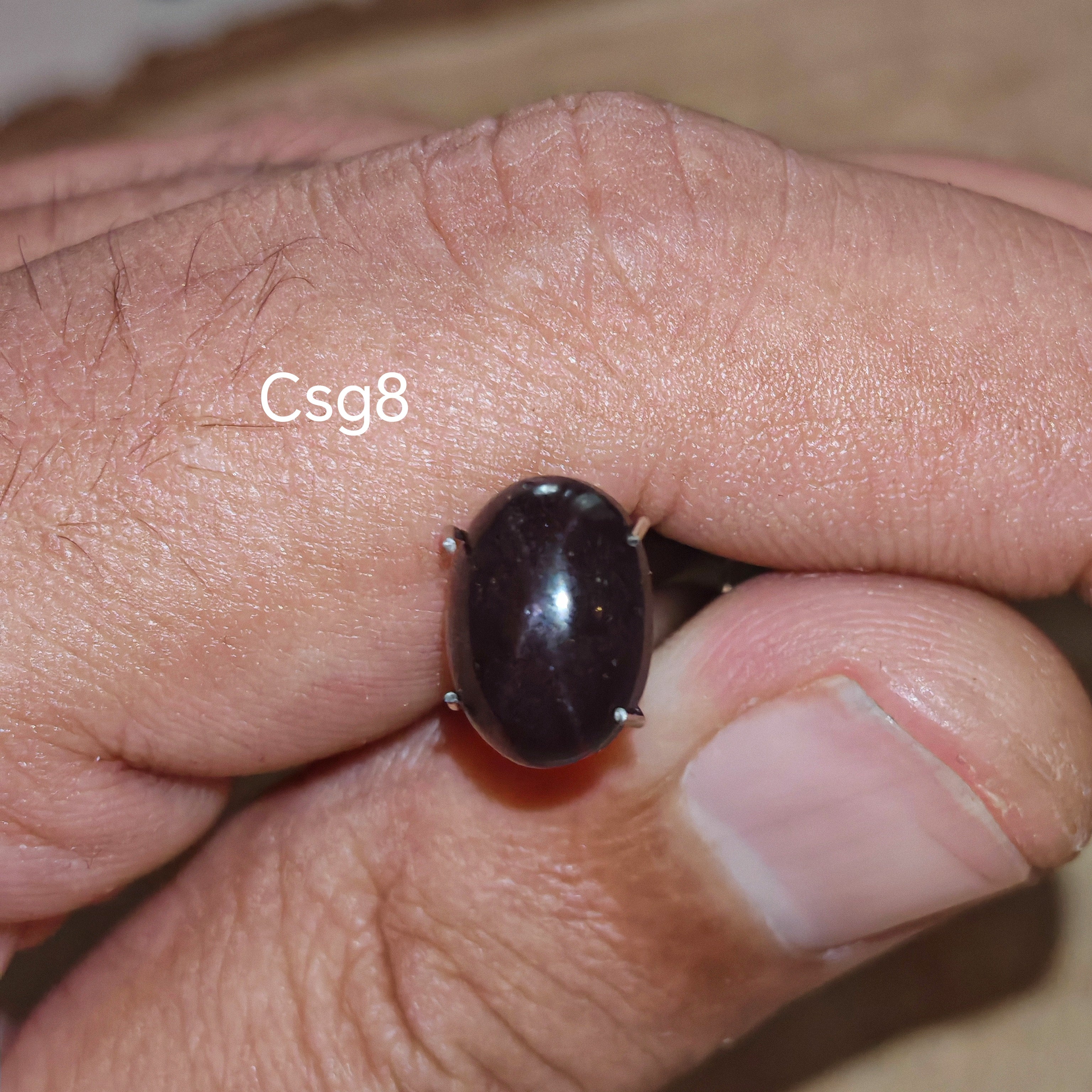 Star Garnet kabochon Csg8 – természetes csillag gránát kő kézben tartva, sötét bordó szín
