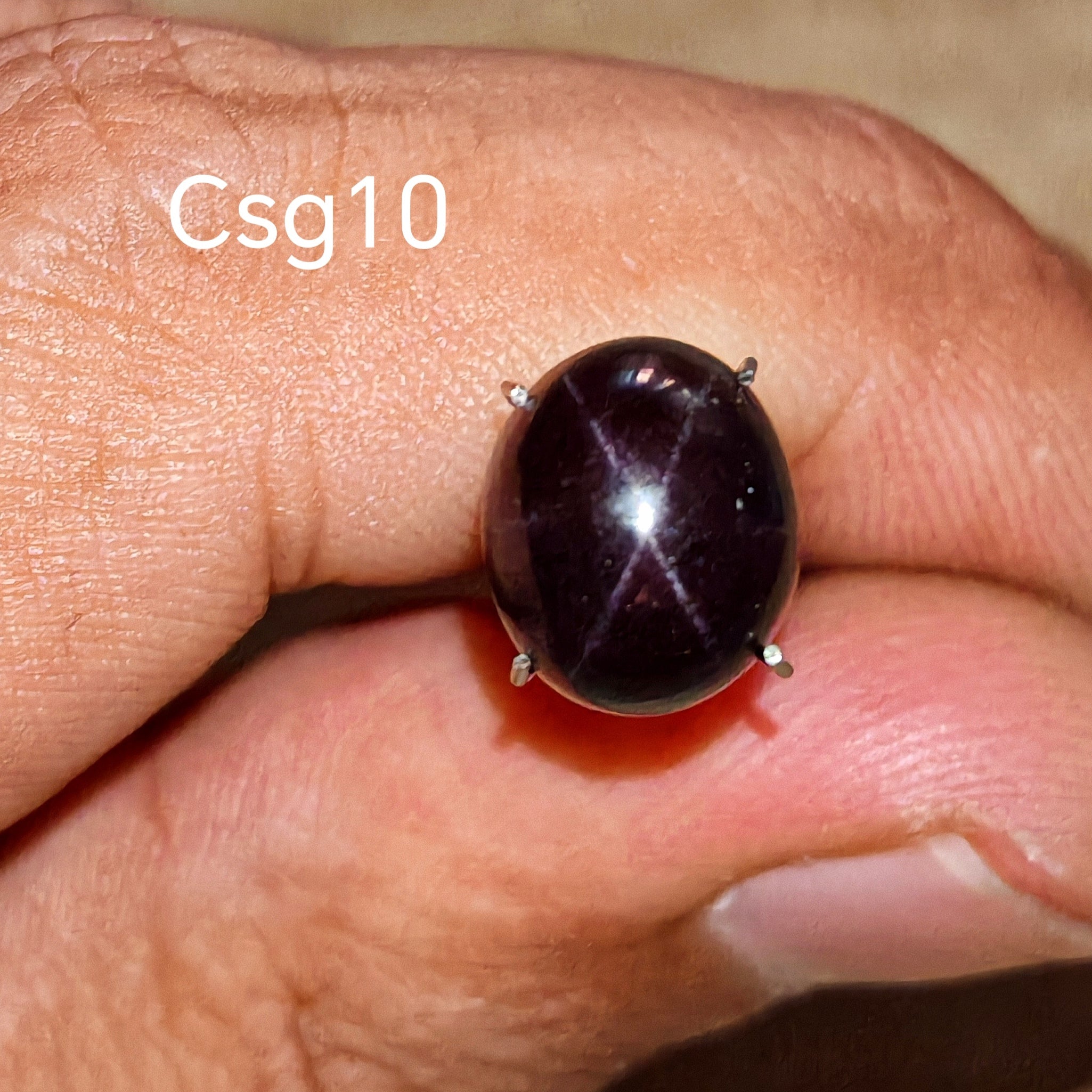 Star Garnet kabochon Csg10 – természetes csillag gránát kő kézben tartva, sötét bordó szín
