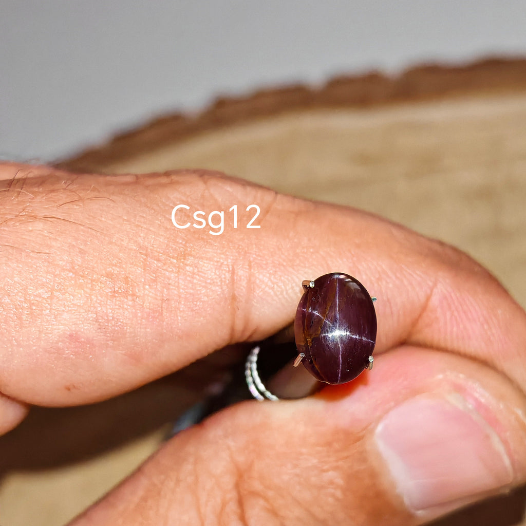 Star Garnet kabochon Csg12 – természetes csillag gránát kő kézben tartva, sötét bordó szín
