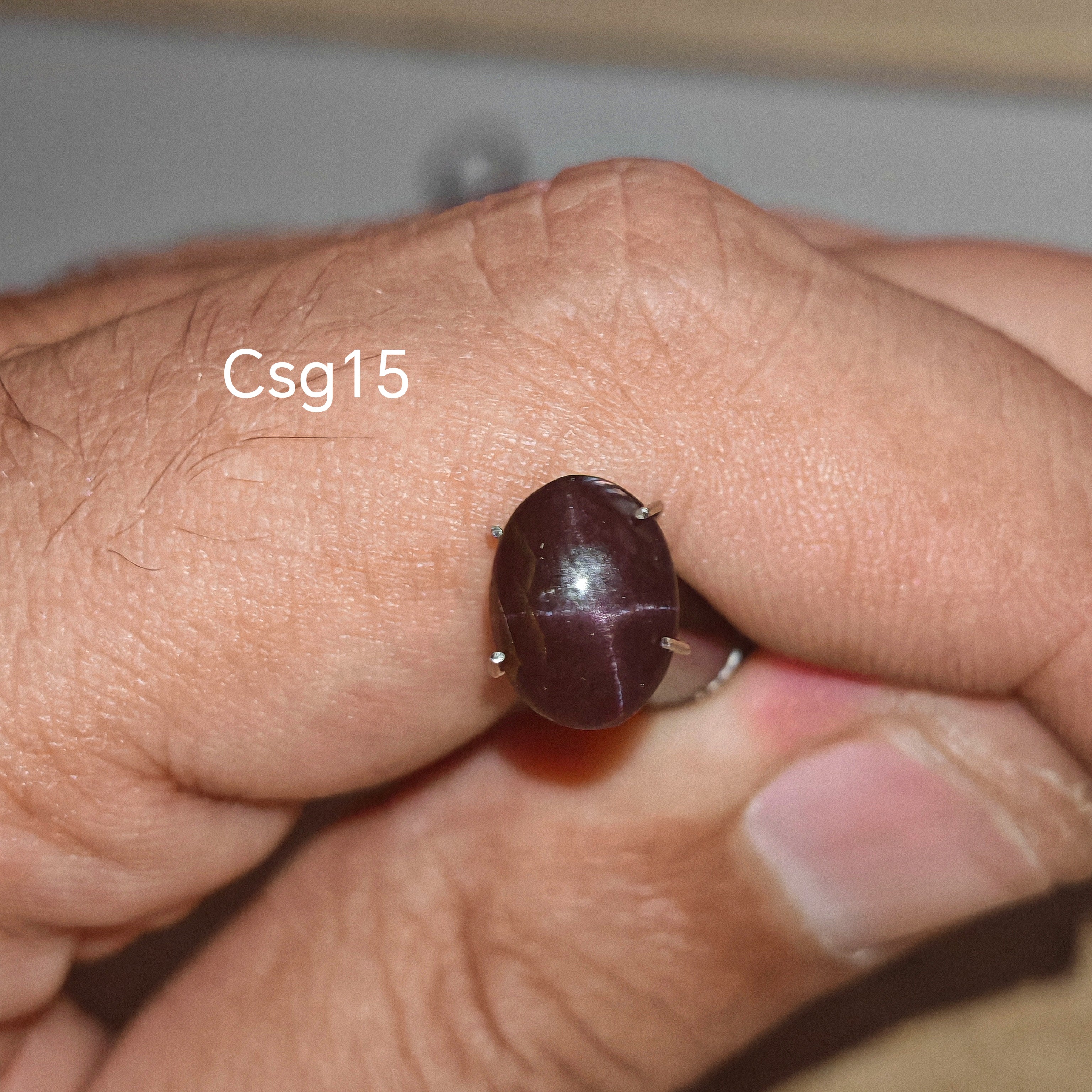 Star Garnet kabochon Csg15 – természetes csillag gránát kő kézben tartva, sötét bordó szín
