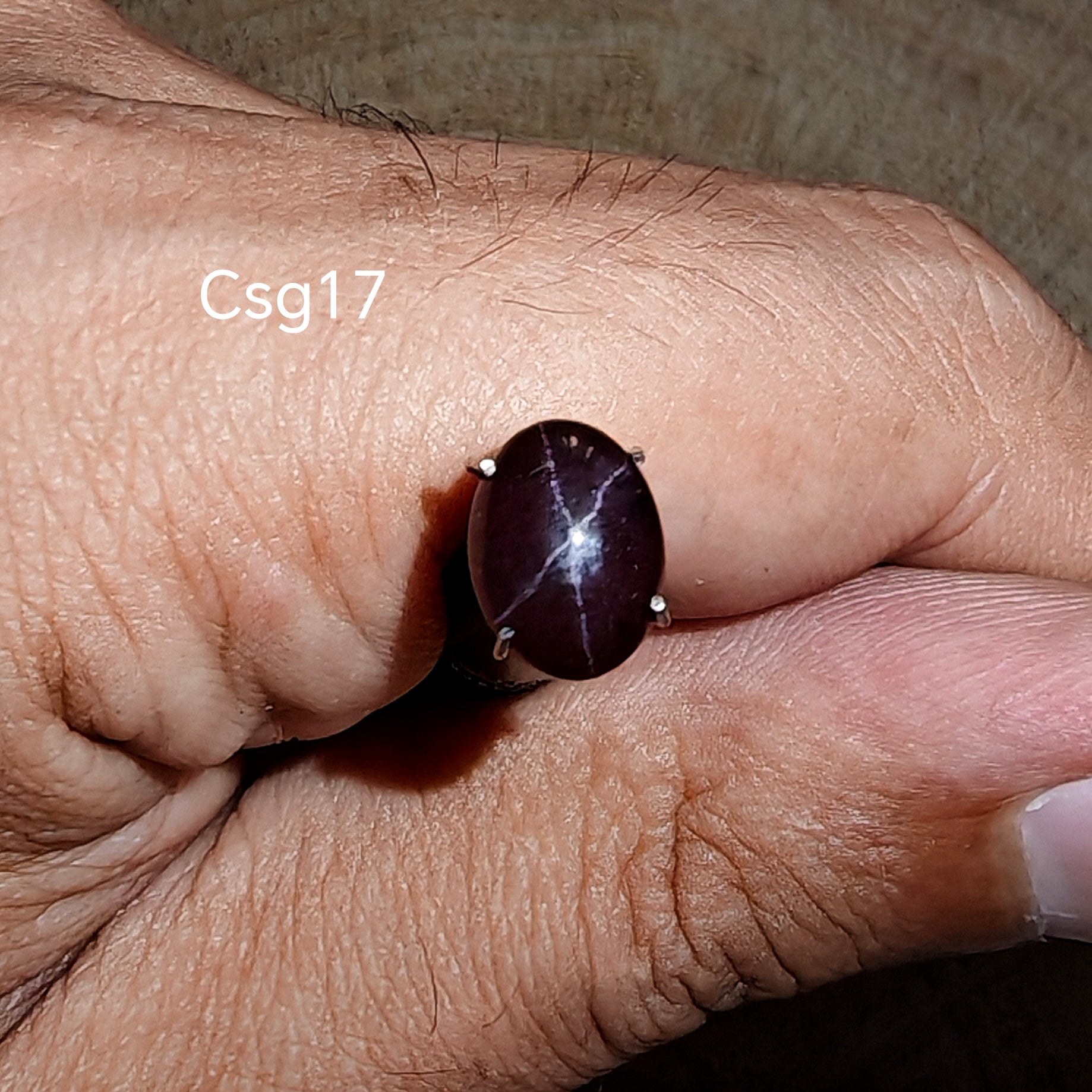 Star Garnet kabochon Csg17 – természetes csillag gránát kő kézben tartva, sötét bordó szín

