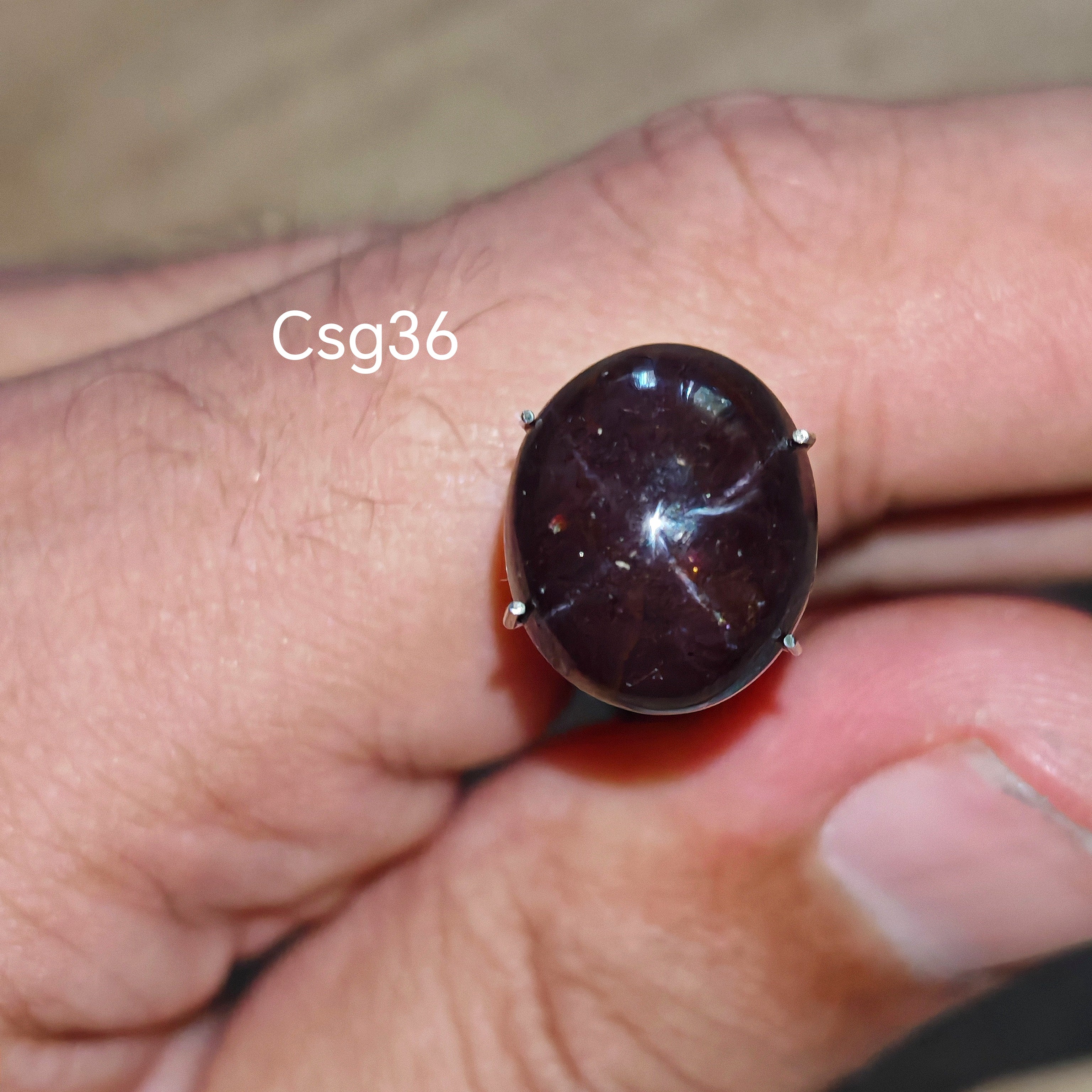 Star Garnet kabochon Csg36 – természetes csillag gránát kő kézben tartva, sötét bordó szín
