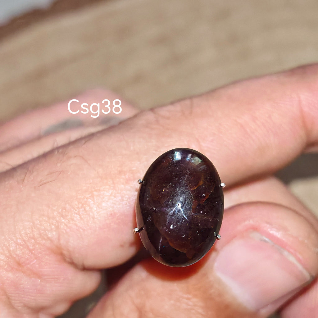 Star Garnet kabochon Csg38 – természetes csillag gránát kő kézben tartva, sötét bordó szín
