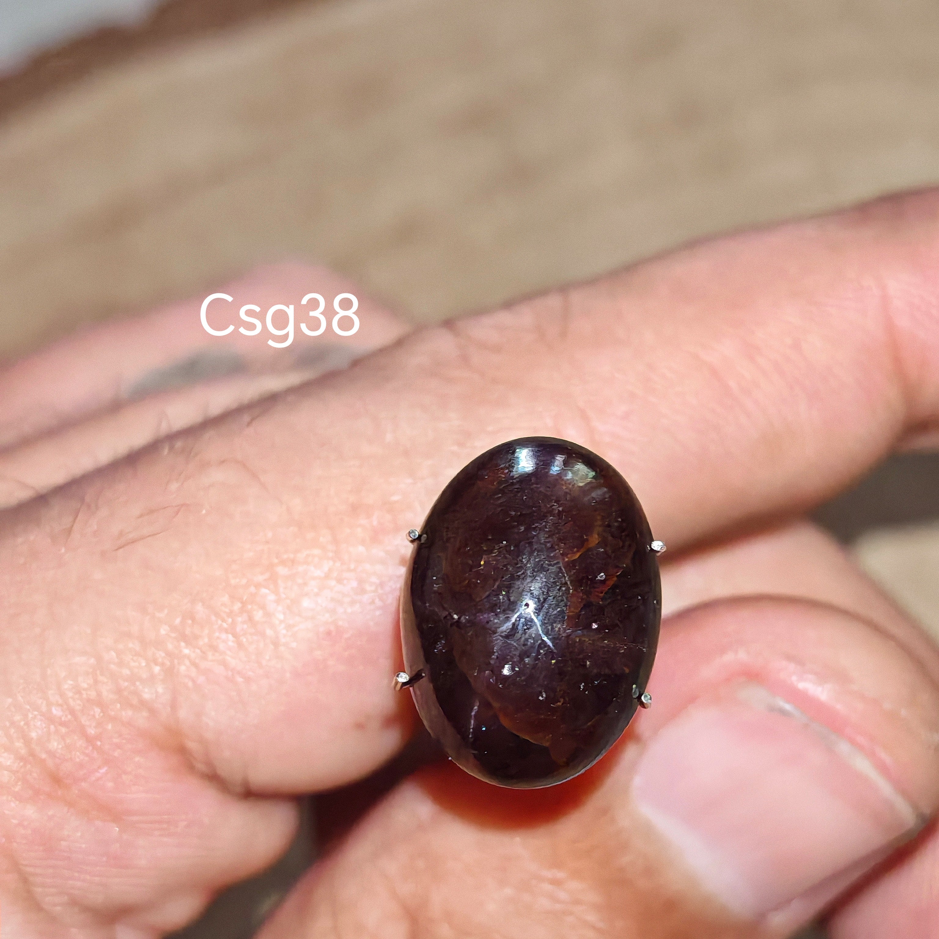 Star Garnet kabochon Csg38 – természetes csillag gránát kő kézben tartva, sötét bordó szín
