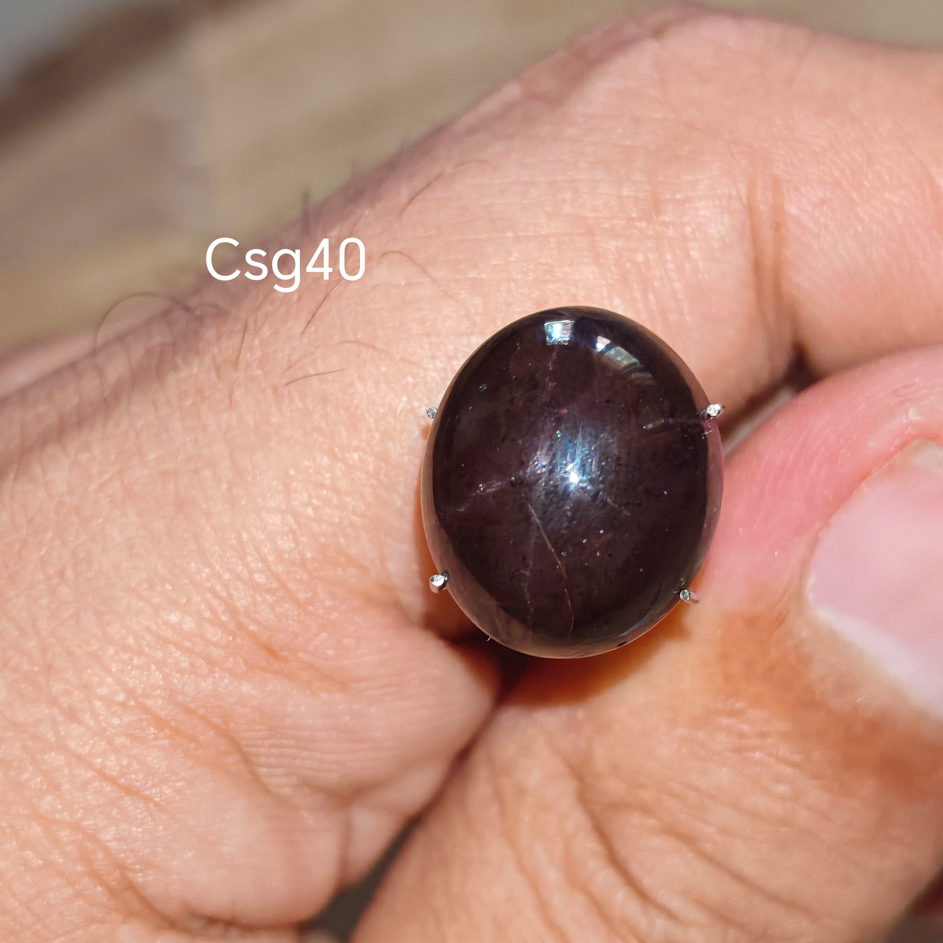 Star Garnet kabochon Csg40 – természetes csillag gránát kő kézben tartva, sötét bordó szín
