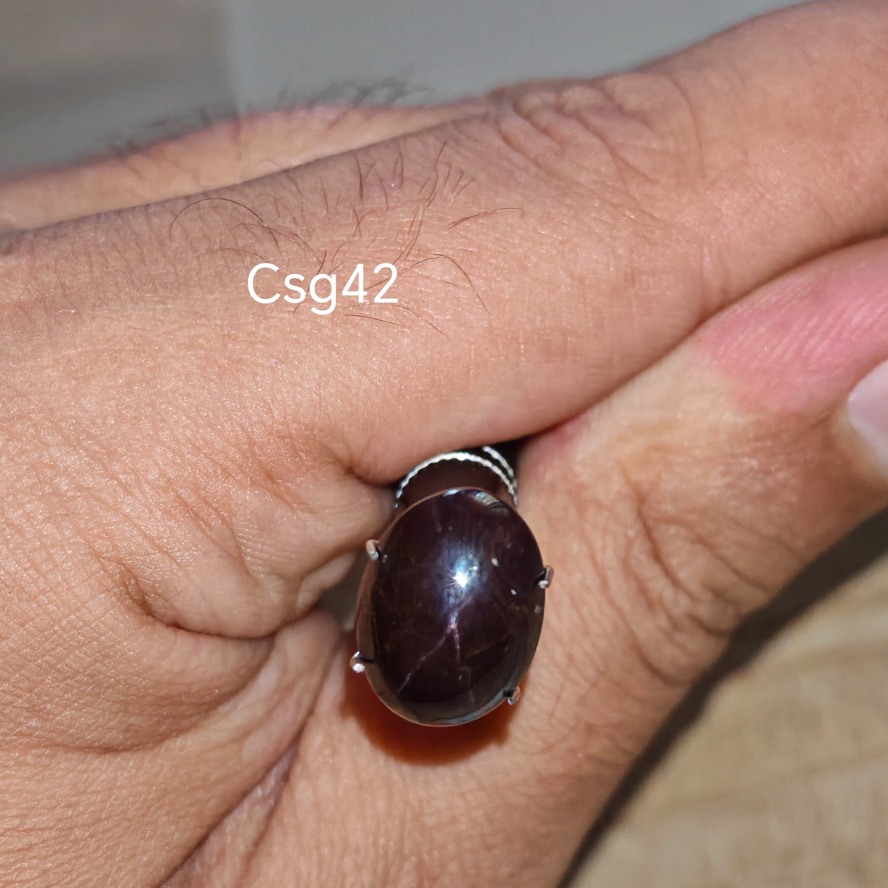 Star Garnet kabochon Csg42 – természetes csillag gránát kő kézben tartva, sötét bordó szín
