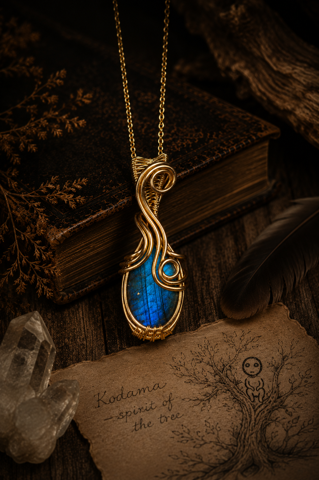 Brigid's Flame kézzel készített kék labradorit sárgaréz drótfonásos medál arany láncon lógva, régi könyvek és kvarc kristály a háttérben – YourCrystal
