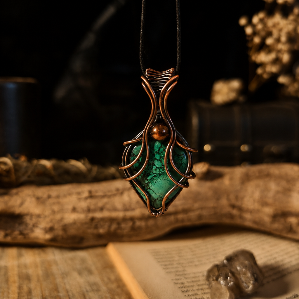 Branch of Yggdrasil malachit vörösréz drótfonásos medál fekete zsinóron lógva, nyitott könyv és ásványok előtt – YourCrystal