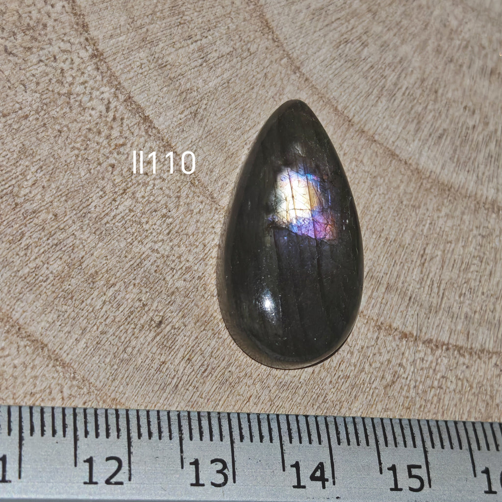 Lila labradorit kabochon Ll110 – körte alak, diszkrét kék flash, vonalzóval mérve