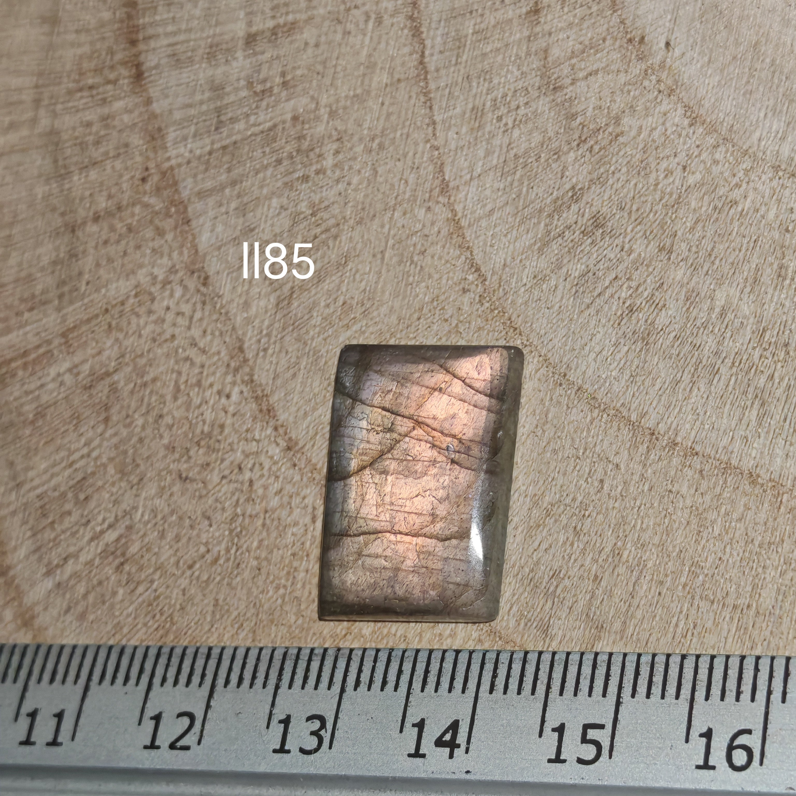 Lila labradorit kabochon ll85 – hosszúkás téglalap alak, réz-narancs-rózsaszín flash, vonalzóval mérve